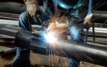 Image of a man welding pipe in water treatment