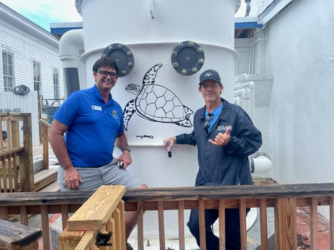 World-renowned marine life Artist Wyland drawing on a DeLoach-manufactured degasifier at the Key West Aquarium